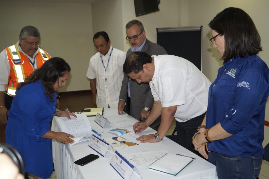 Gabriel Rubí signing on behalf of National Disaster Risk Management System (NDRMS), the first printed copy of the Protocol of the National Early Warning System for Droug