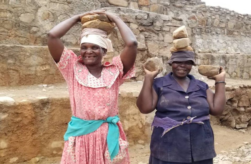 smiling women rebuilding dam