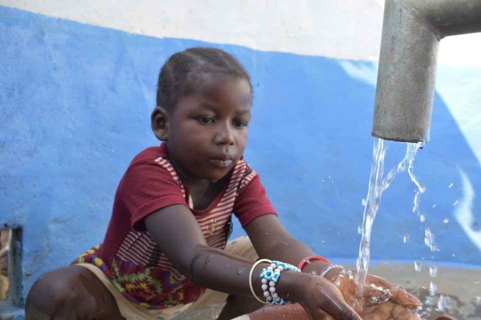 DSC_0206 A child plays with a new water source during a visit by Jerry Grant to a WaterShare project in Sierra Leone in February 2020.