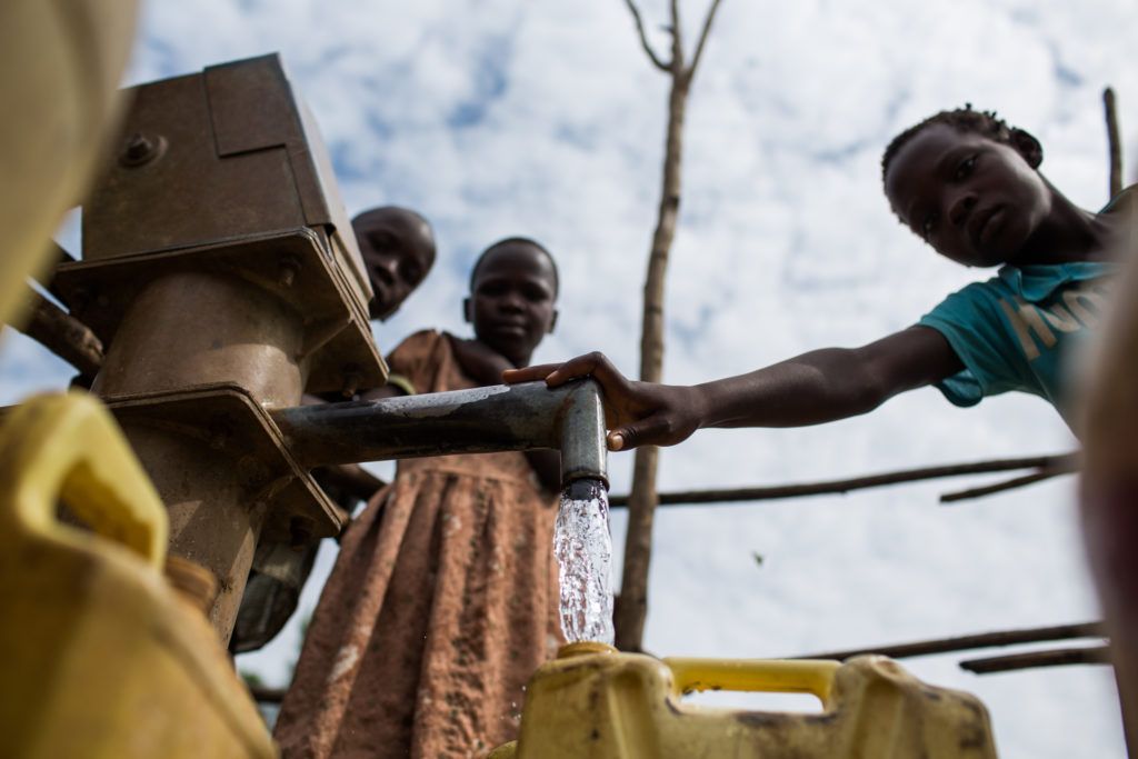 A water source supported by GOAL in Uganda, being used to fill a water canister by children. WASH