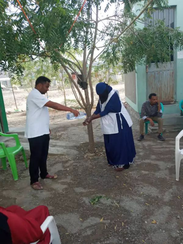 COVID-19 Ethiopia. GOAL refugee programme staff demonstrate how to wash hands properly and exercise social distancing to Eritrean refugees in Aysaita refugee camp
