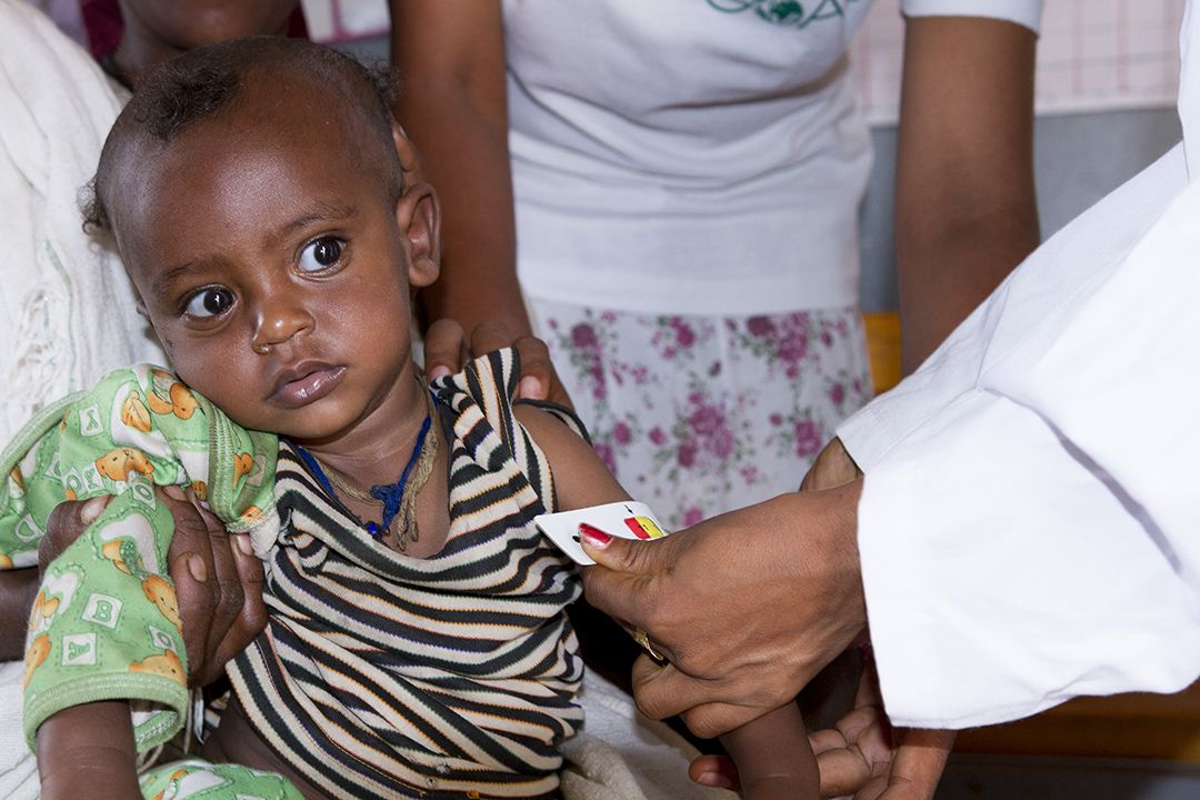 Ende Mariam Health Post, Aheferom Woreda, Tigray Region, Ethiopia, where the Community Management Acute Malnutrition (CMAM) programme is carried out. Health Extension Worker Tigist and Trainee Nurse Ergibe screening MUAC a 9 months old baby Mehrawi siting with her Mother Krstu Berehe. Photo: Anteneh Tadele/GOAL_April_2016