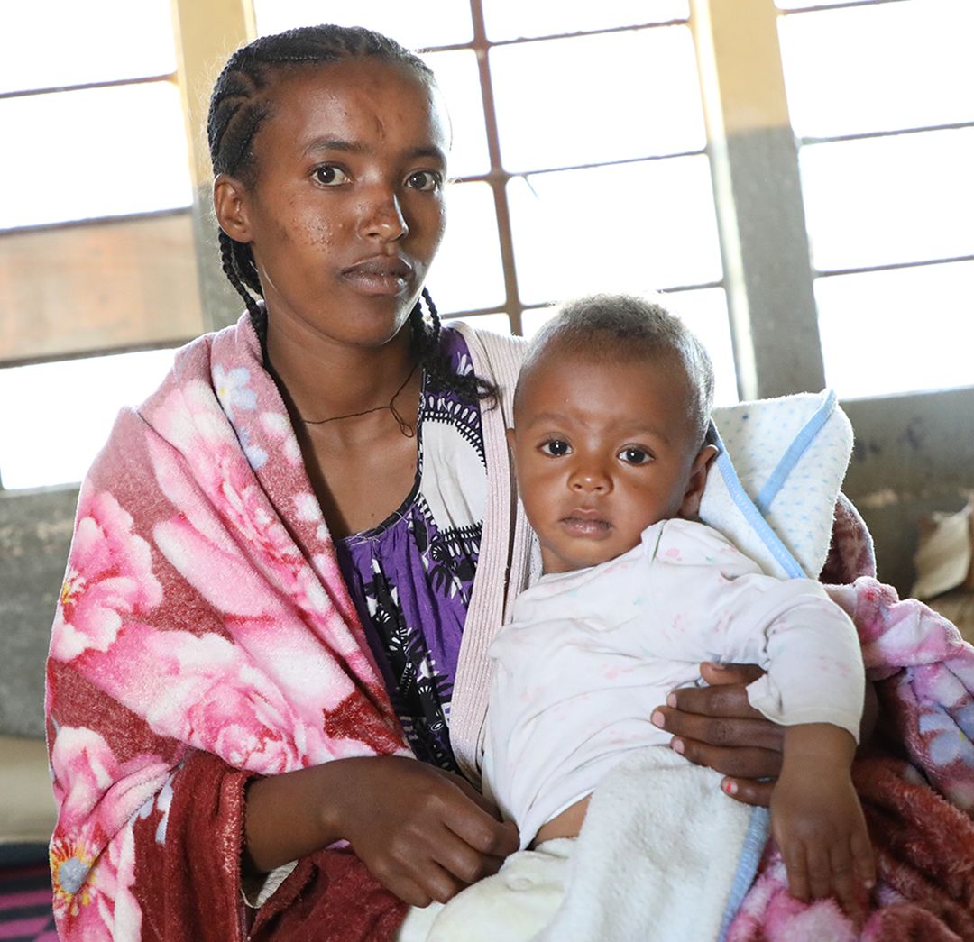 Ethiopia-Tigray-Haregewoyne-Biruk-zoom Haregewoyne and her young son Biruk in the internally displaced persons (IDP) camp teams have set up in a local school.