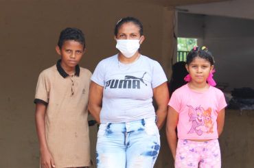 Eva with her son Daniel and daughter Elianis in front of their new home in Colombia