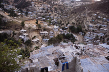Sprawling settlements of poor housing on the outskirts of Port-au-Prince, Haiti. Population pressure has forced people to build further and further up the hill away from the coastline. This is very dangerous, as rainstorms can cause flooding and the collapse of such areas.