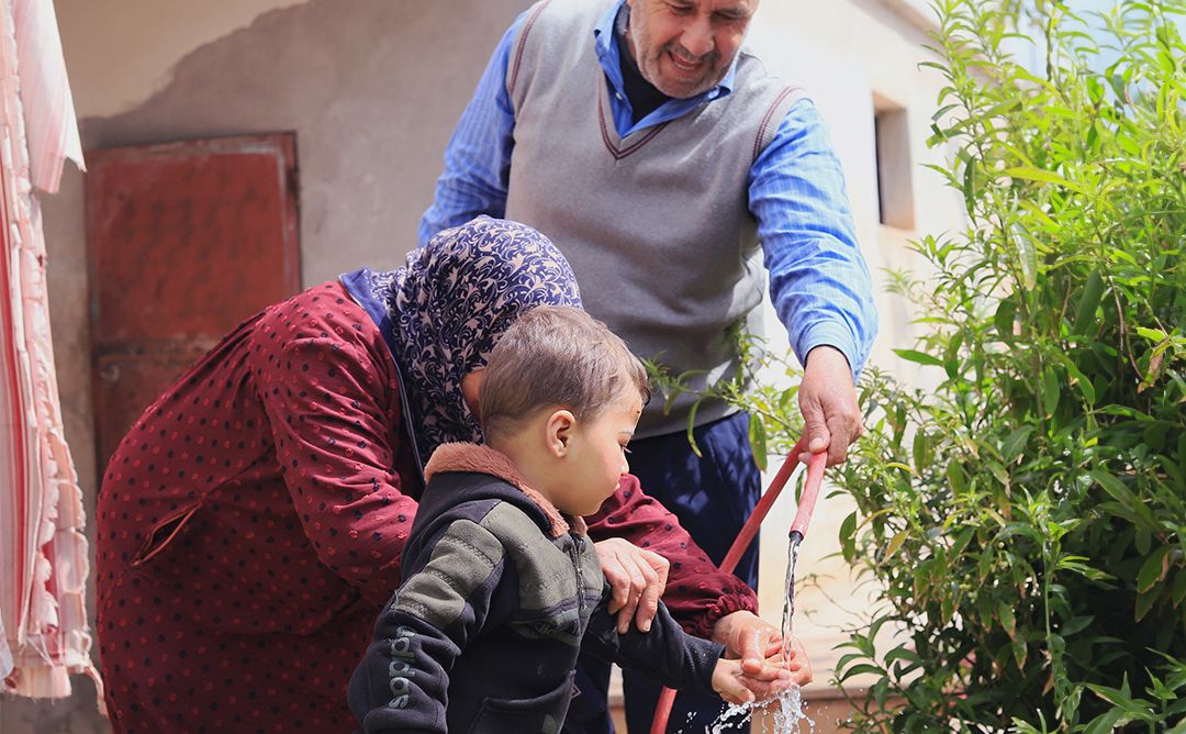 Syria_Relief IV_WASH_Water Tower Restoration_Benecifiaries_Washing Eine syrische Familie wäscht sich in Idleb im Nordwesten Syriens die Hände mit kürzlich wiederhergestelltem Leitungswasser.