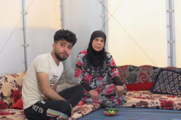 Um Rahman and her son Ahmad (21), taking a break from work at their family’s Relief Housing Unit. Photo: Idleb, Syria. April 2024.