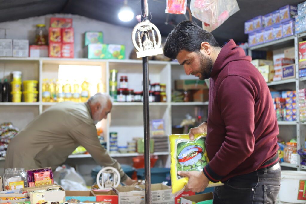 Khaled Al-Hassan -38-years-old- buys food at the market in southeastern Idlib countryside, after receiving GOAL’s food cash assistance