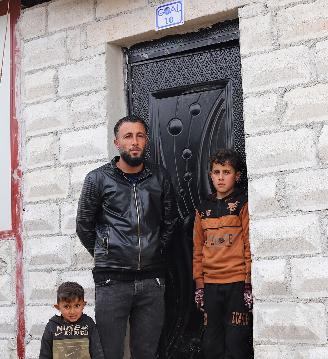 Sanad-Tariq-Syria-family-new-home Tariq and his sons Hamza and Munther stand in front of their new home