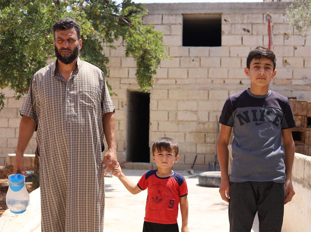 Ahmed Al-Ibrahim -45 years old- with his two sons, Abdulmalik, -14 years old- and Omar -4years old- in the village of Haysh, south of Maarat Al-Numan, Idlib. 