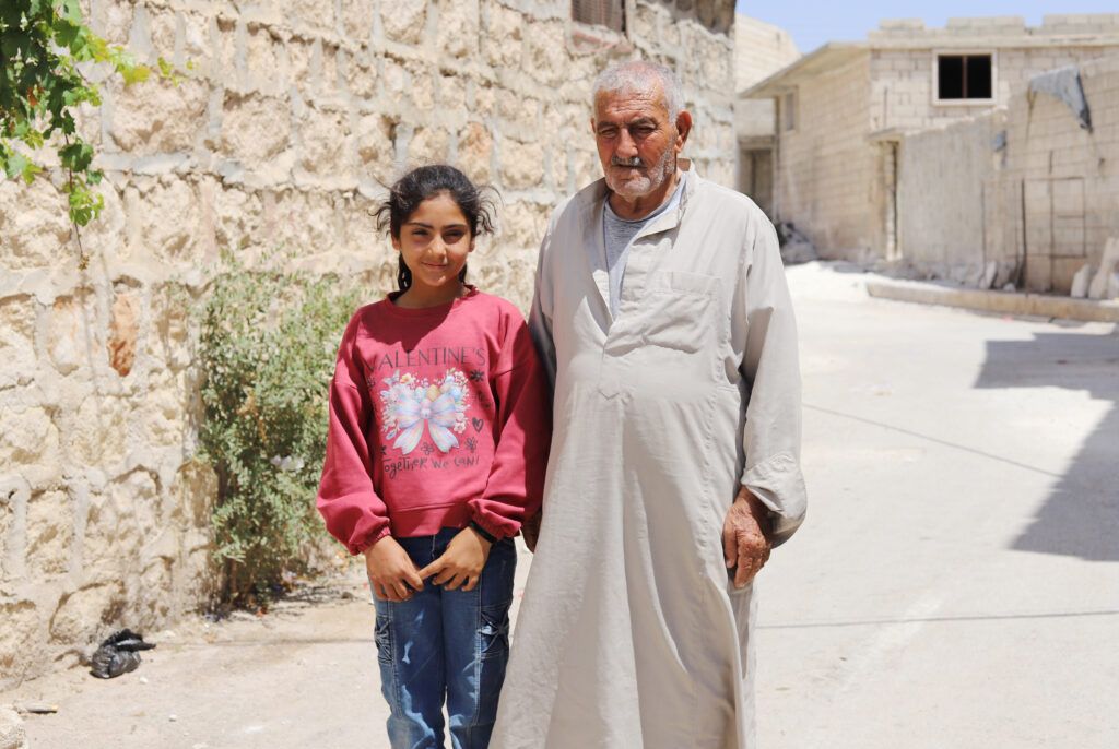 Mohammad with his granddaughter Noor, 10, in their town in the Western Aleppo countryside.