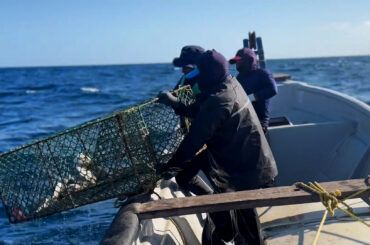 Fishermen in Colombia in gas-fueled boats that has reduced cost of fuel and better for environment thanks to GOAL Innovation Lab